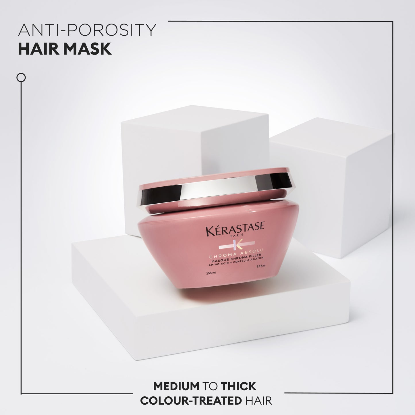 A pink jar of the Kerestase Chroma Absolu Masque Chroma Filler 200ml, perfect for medium to thick color-treated hair, sits gracefully on a white geometric pedestal against a minimalist backdrop.