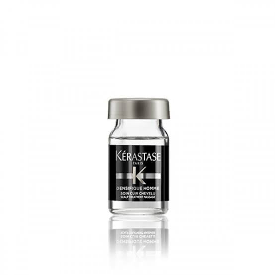 A sleek, compact glass bottle of Kerestase Densifique Homme hair treatment features a clear liquid and is topped with a silver cap. The label stylishly presents the brand name and product details in white text set against a sophisticated black background, enhancing its elegance.